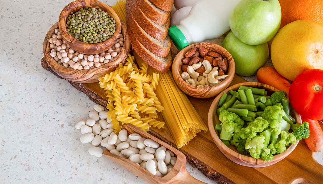 A collection of healthy food, including beans and chickpeas, spread out on a table